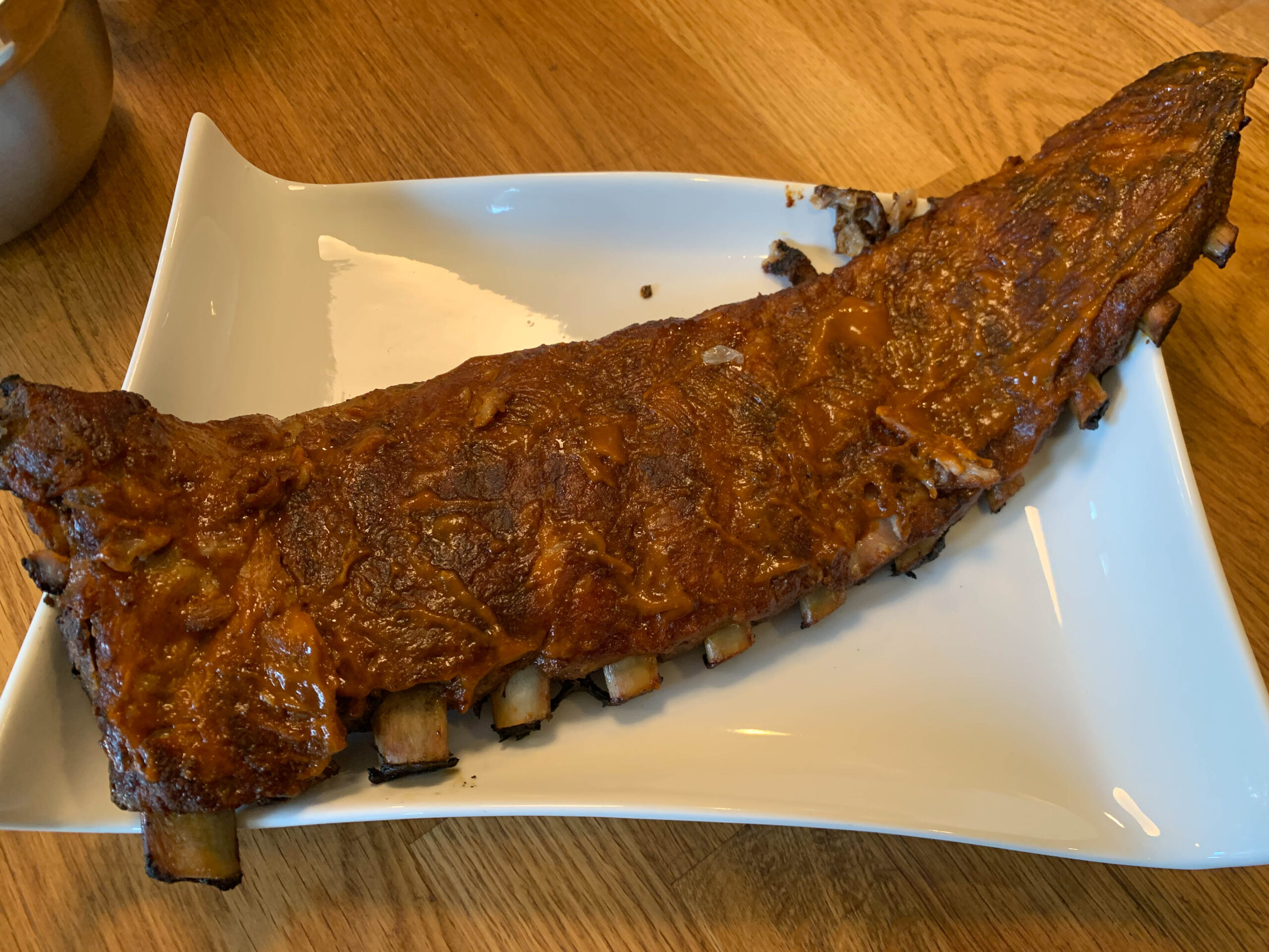 Whole rack of Maui BBQ ribs on a serving plate